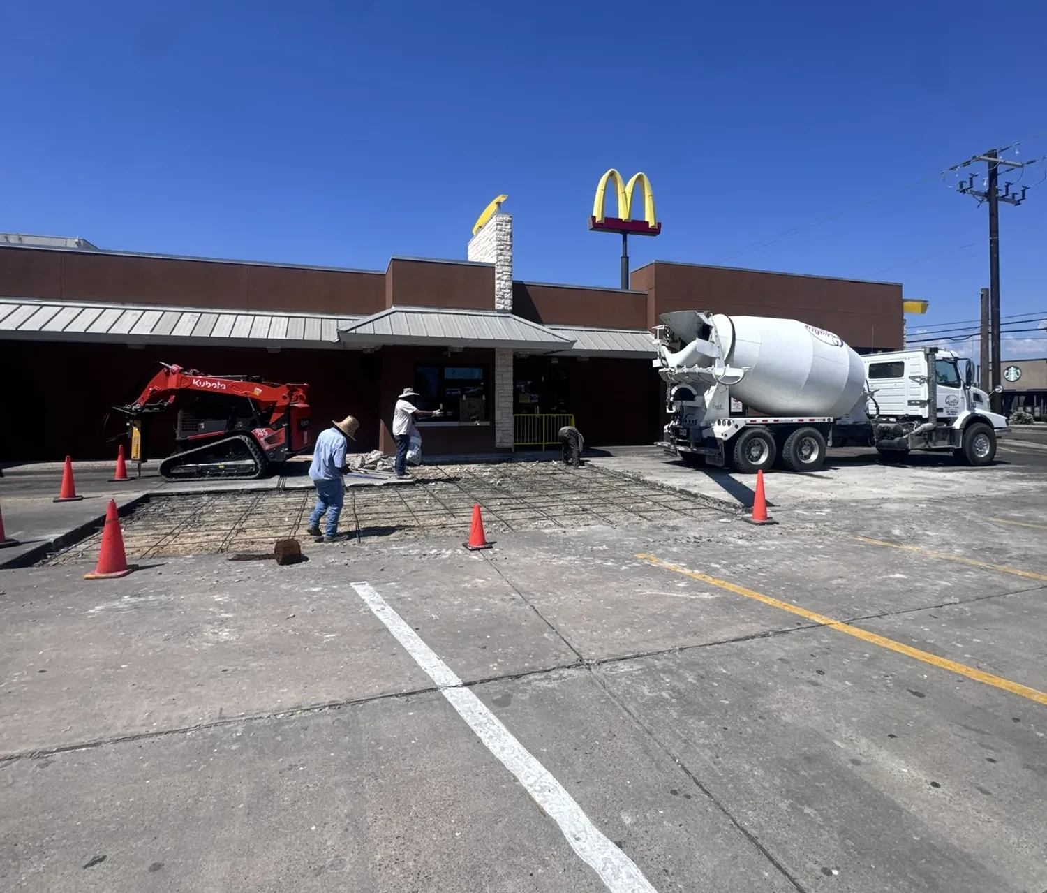 Commercial parking lot concrete pour at a McDonald's with a mixer truck on site by Lucky's Concrete